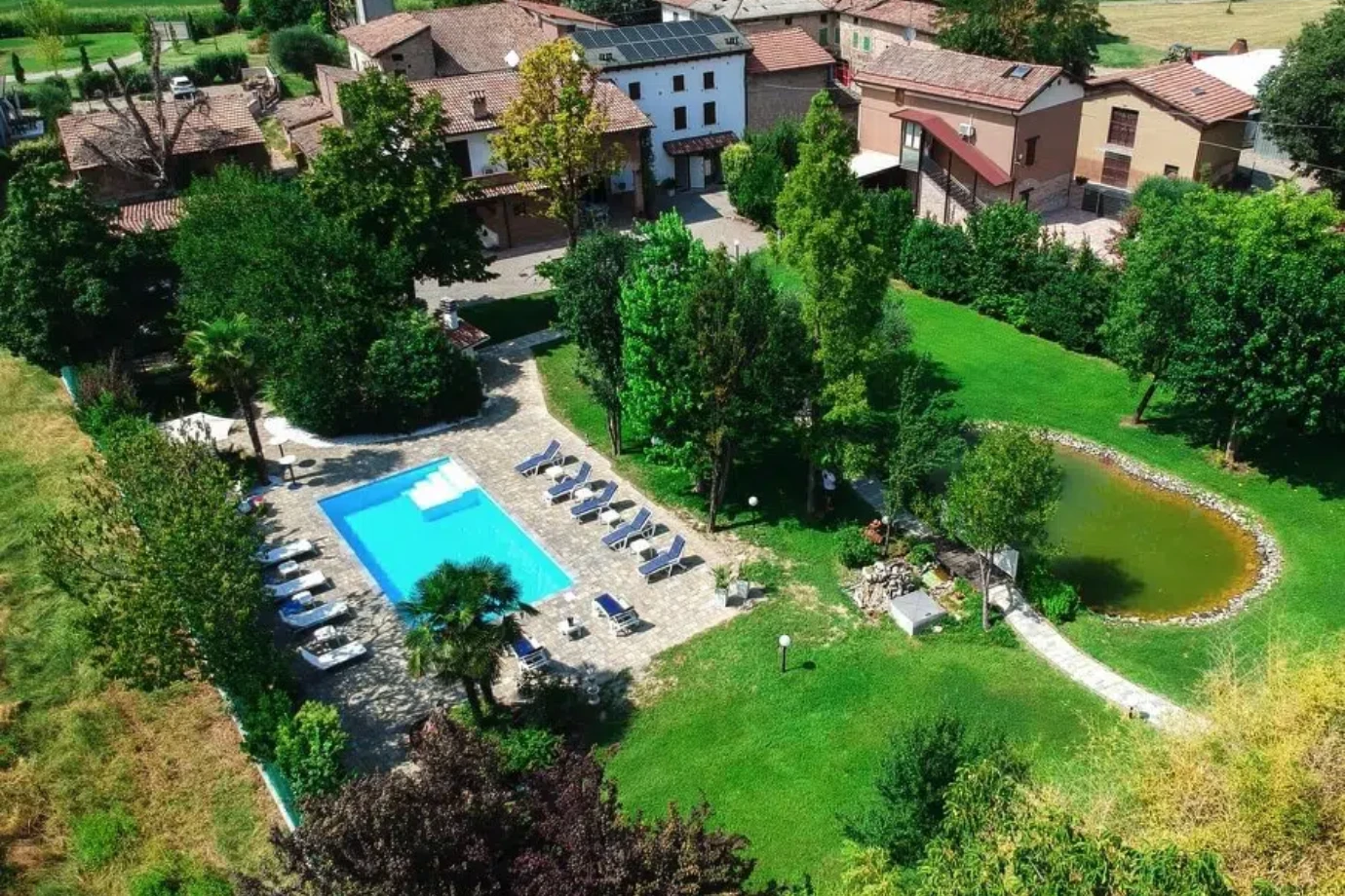 Ca' Ross Resort dall'alto: piscina, giardino e laghetto accanto agli edifici