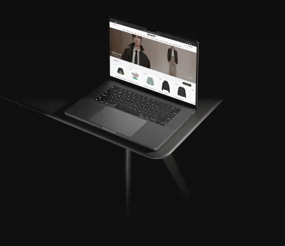 Portatile su un tavolo scuro con aperto un e-commerce di abbigliamento